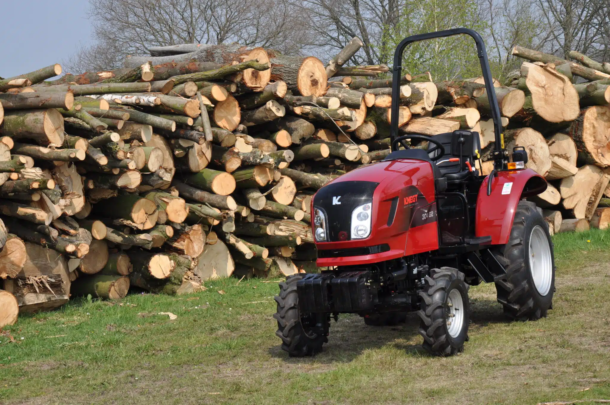 Knegt 30 HP diesel tractor near woodpile